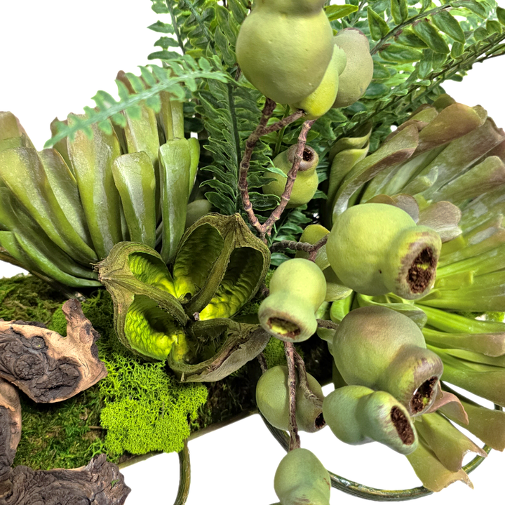 Succulents with Fern, Pods, and Wood Fragments in Metal Boat. FH: 24"H