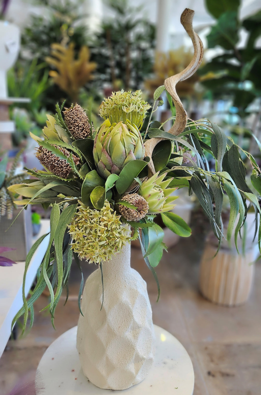 Protea, Eucalyptus, and Banksia with Curly Branch in Textured Ceramic Vase. FH: 37"