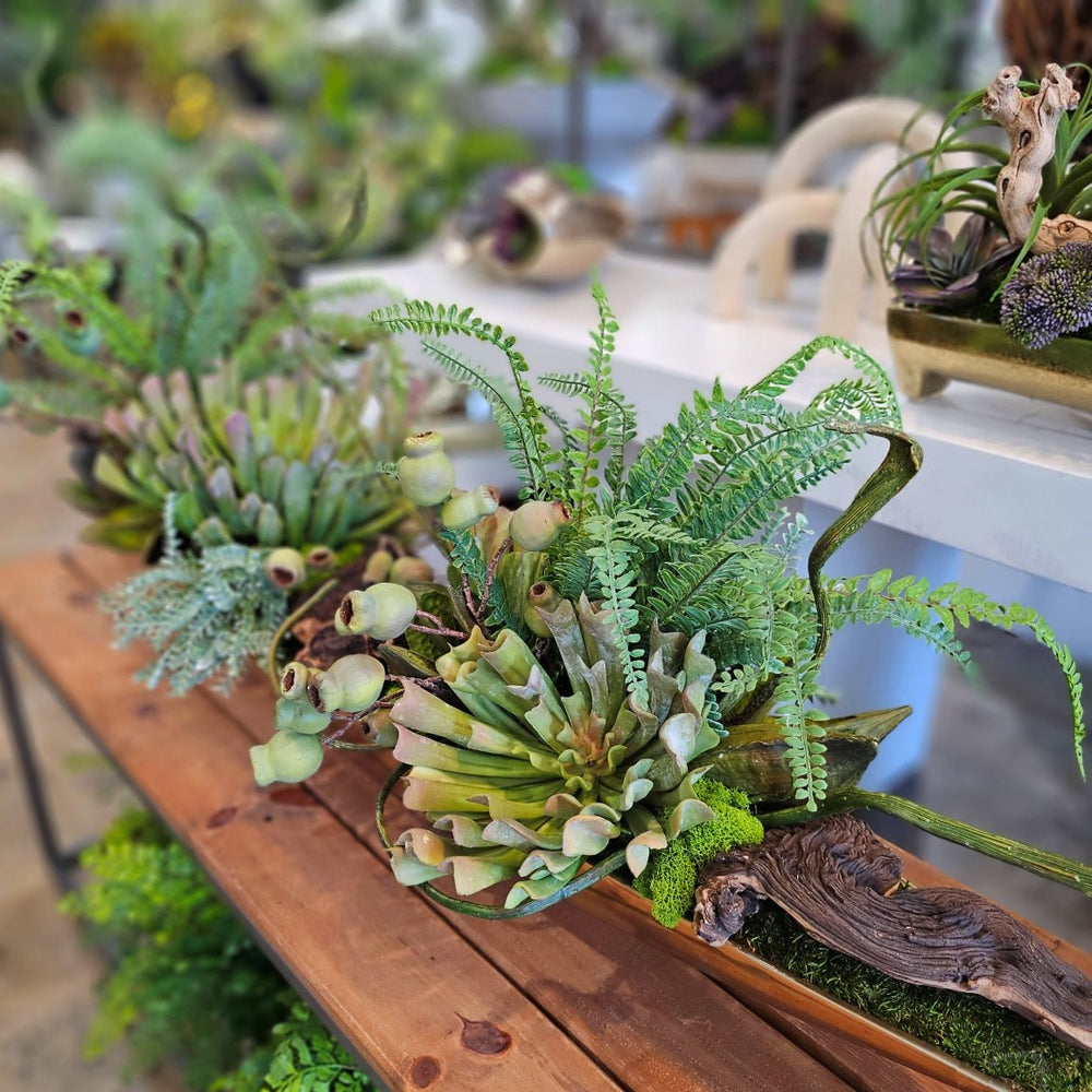 Succulents with Fern, Pods, and Wood Fragments in Metal Boat. FH: 24"H - LDF SilkArtificial Flora